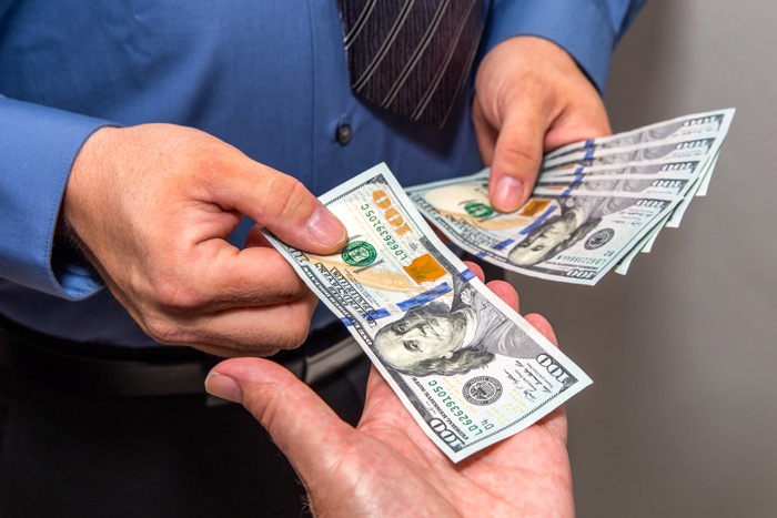 Image of dollars being handled by Hloom Templates released via Creative Commons 